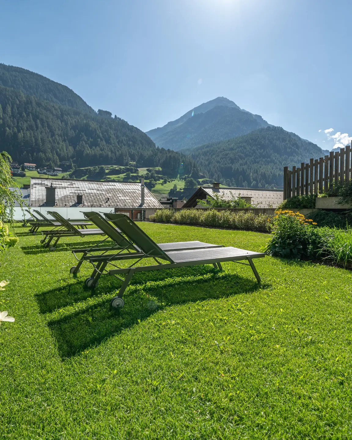 Green lawn with deck chairs in front of an Alpine panorama | © johannes brunner